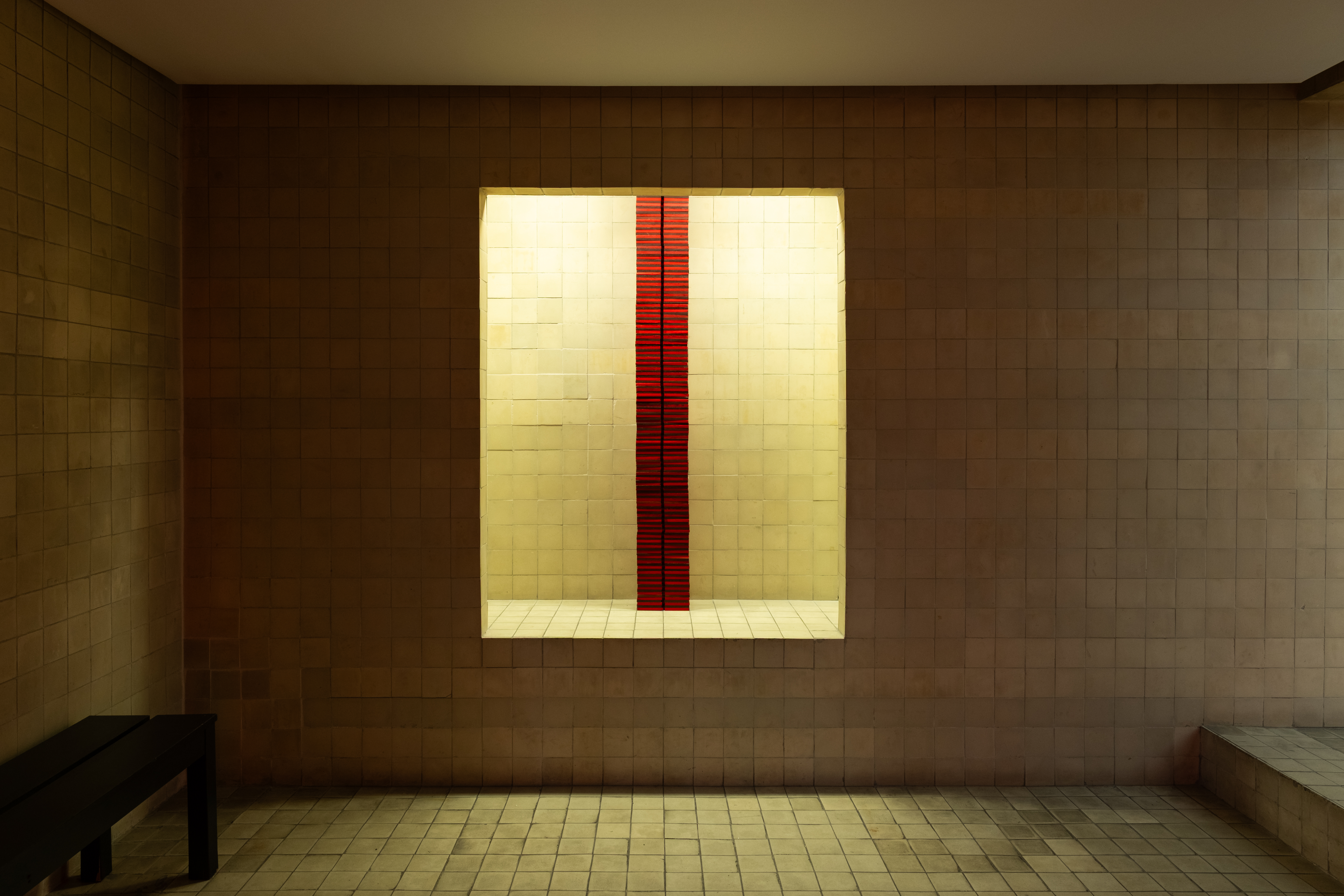 Red modular column glowing in a lit wall niche — Bir Arada installation, Maçka Sanat Galerisi