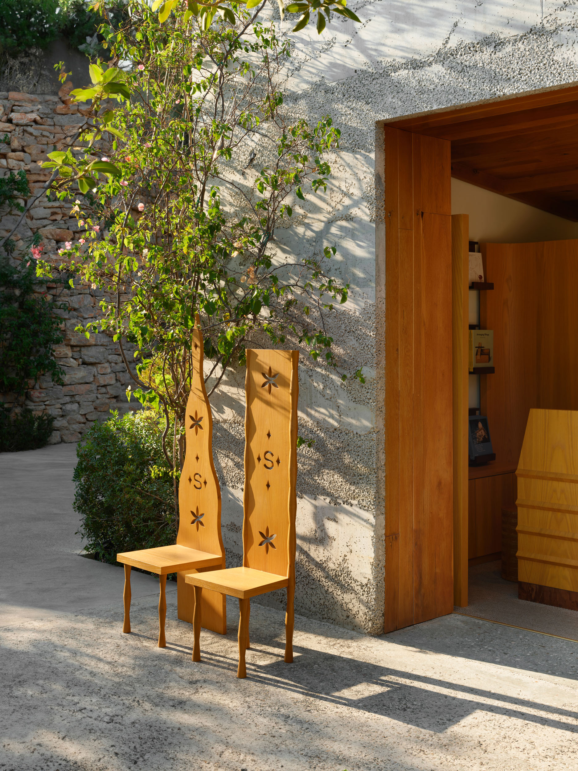 Custom oak chairs with floral cut-outs in the entrance courtyard — Siedrés boutique