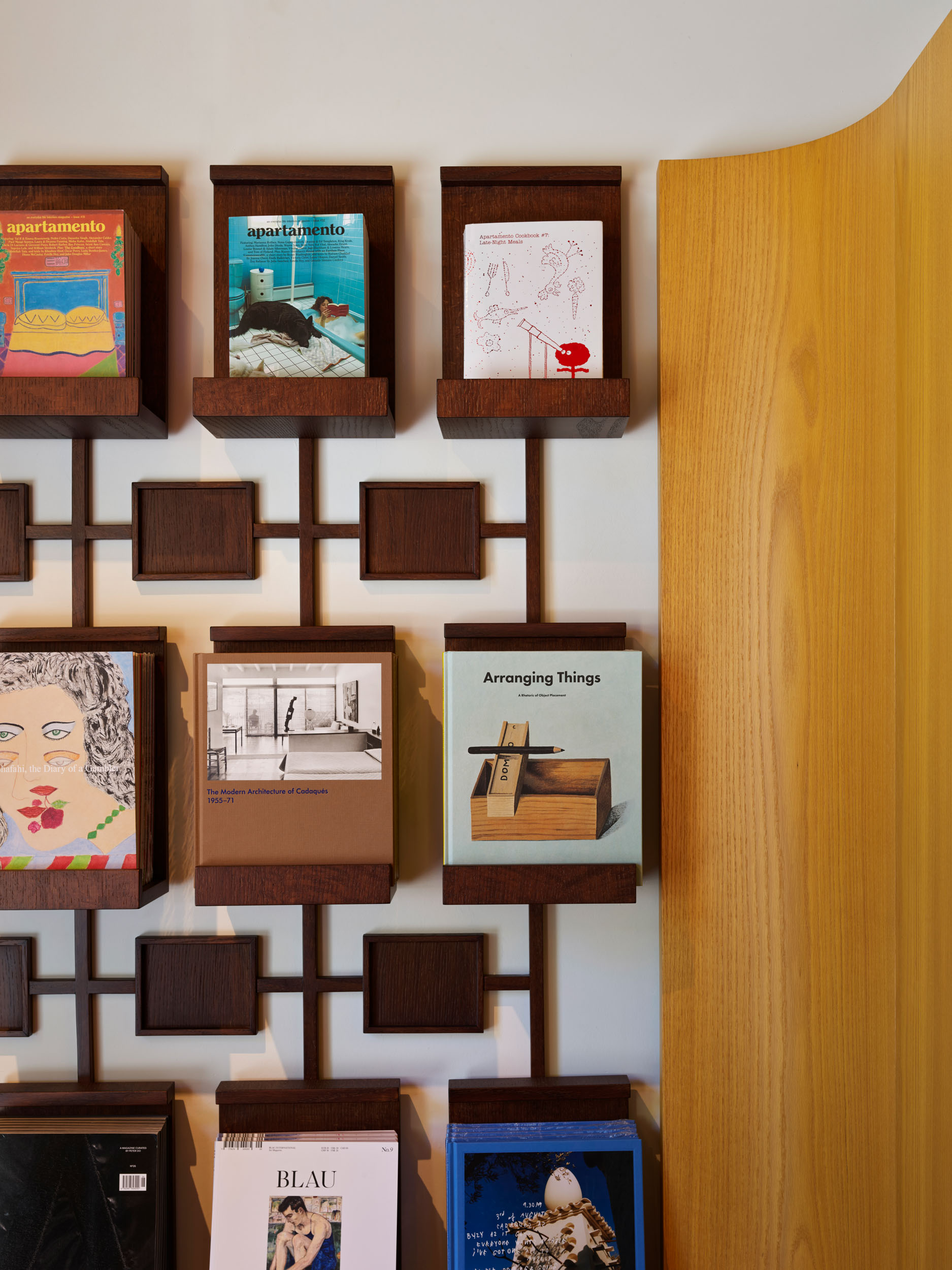 Wall of prints in walnut frames — Siedrés store display detail