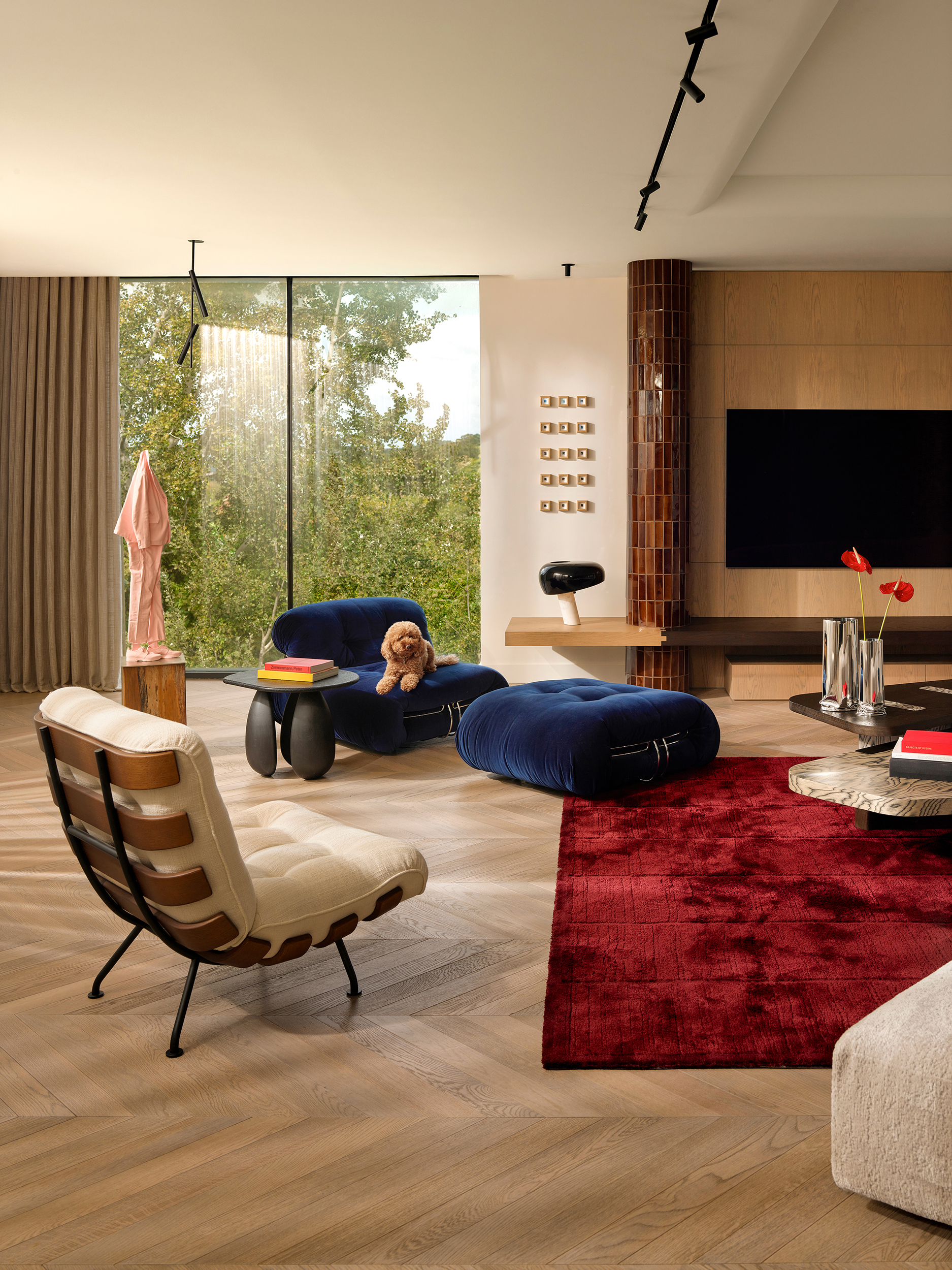 Family lounge with rust-red rug and sculptural seating — Zekeriyakoy TP House