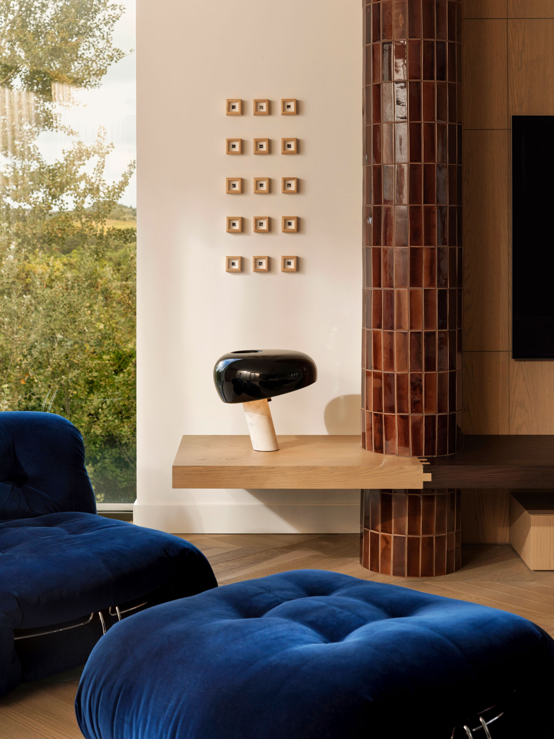 Royal-blue velvet seating beside a brick-clad column — Zekeriyakoy TP House interior