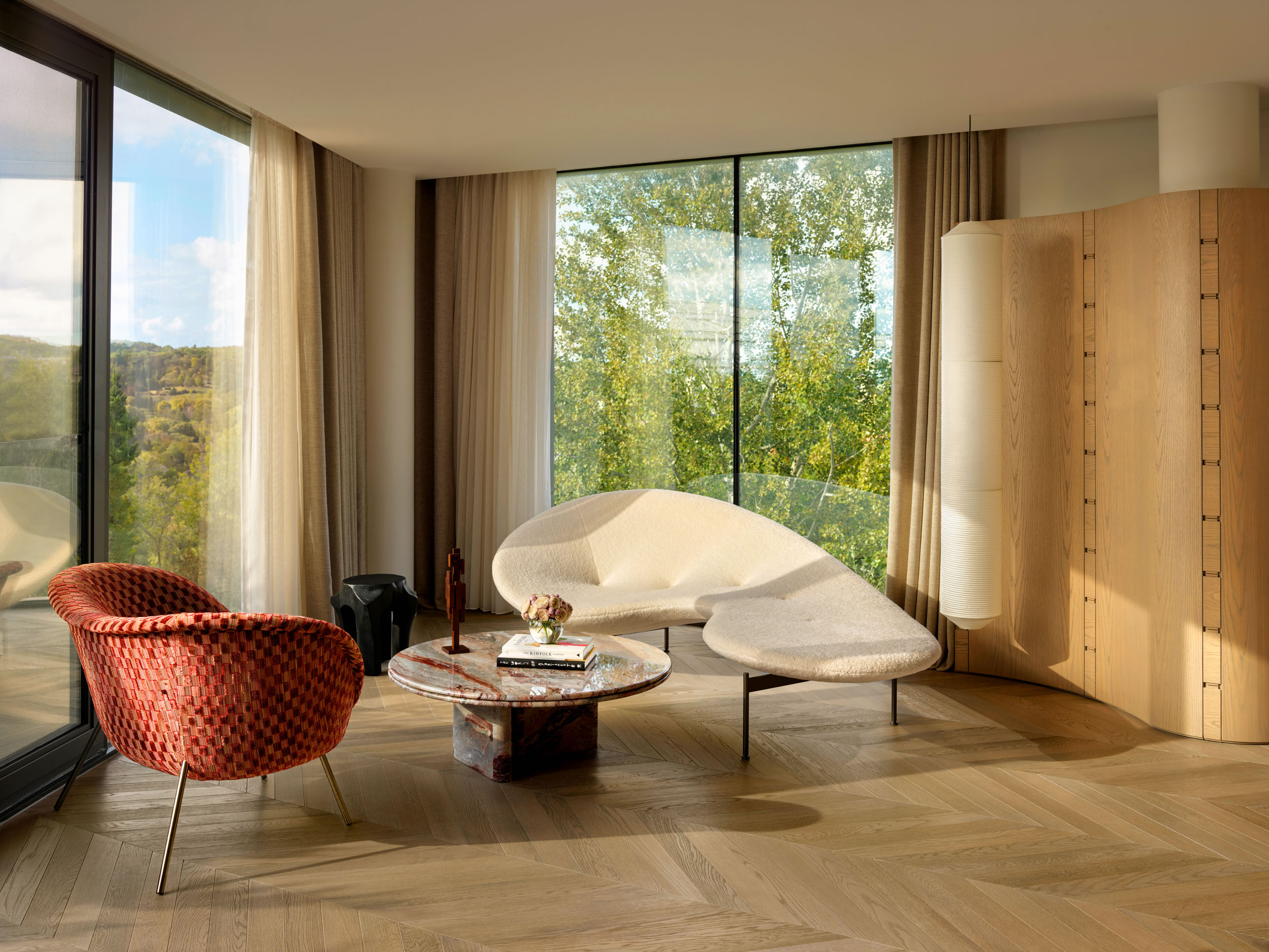 Sunroom with coral armchairs and sculptural cream sofa — Zekeriyakoy TP House, Istanbul